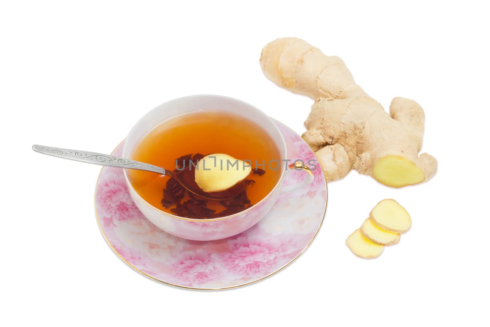 Cup of ginger tea with tea spoon on pink saucer and slices of a ginger against the backdrop of ginger root on a light background
