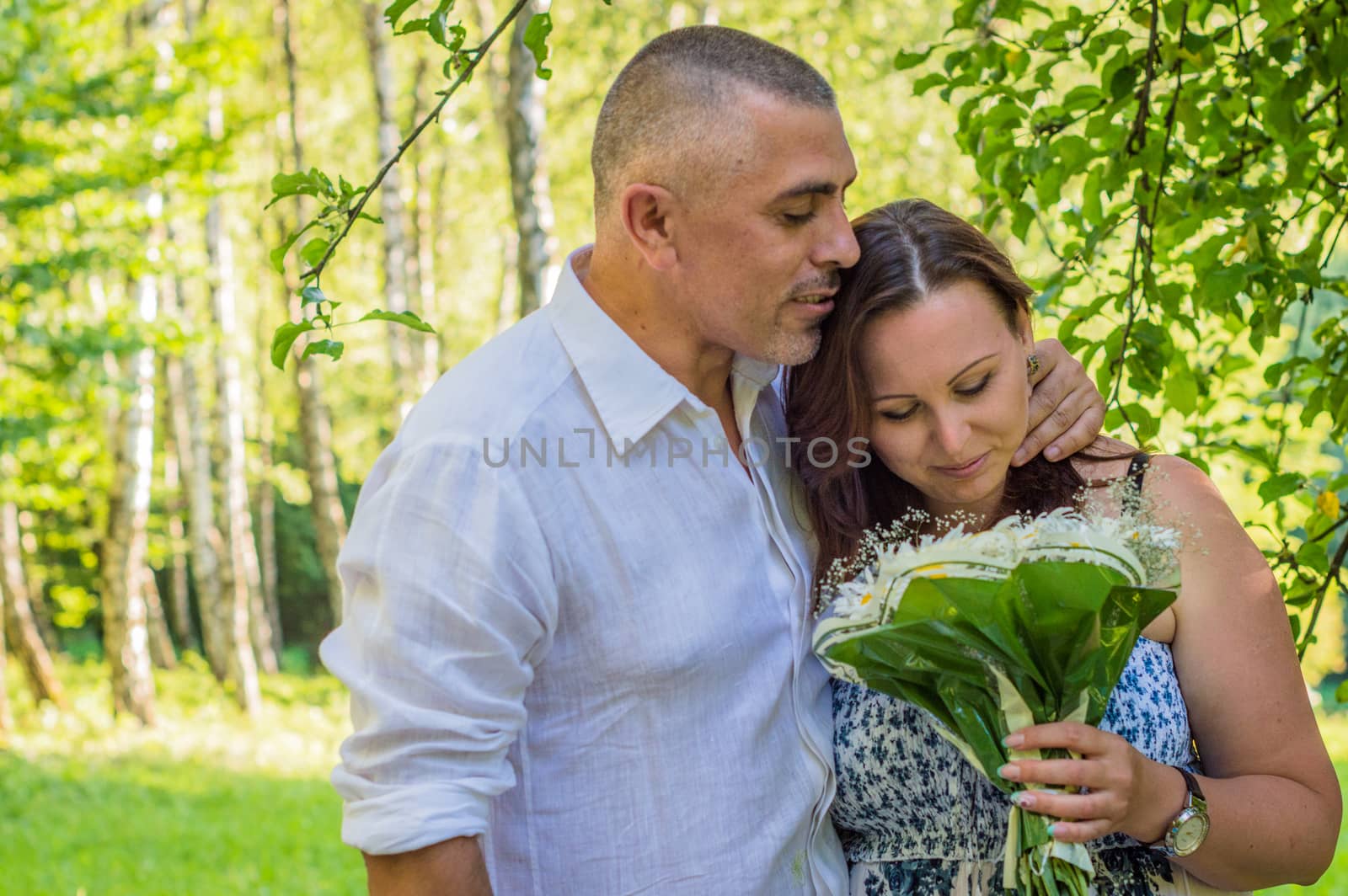 husband with wife and a bouquet of daisies in the Park