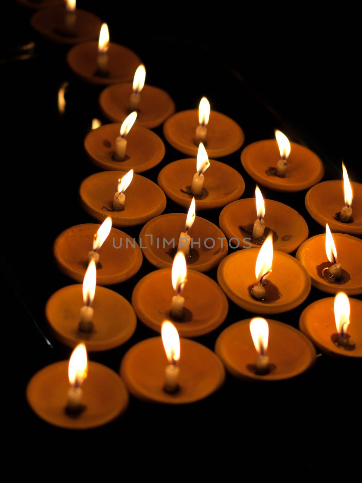 COLOR PHOTO OF OFFERING LIT CANDLES
