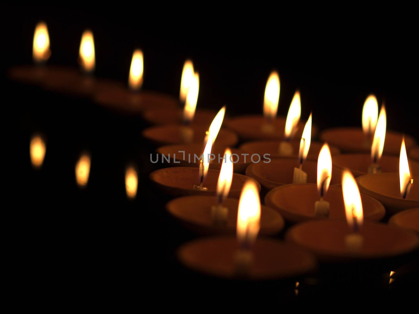 COLOR PHOTO OF OFFERING LIT CANDLES