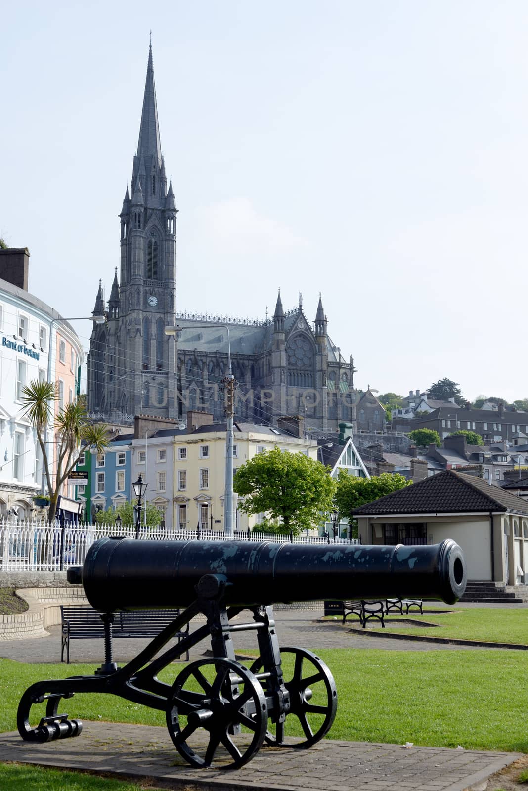 St Colman's Cathedral above cobh town and bay in county cork ireland with canon in foreground