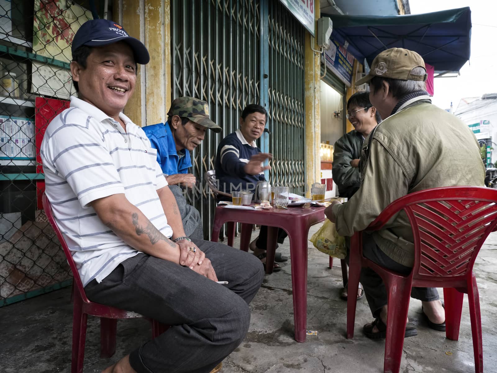 Group of friends chilling out at a street stall in Vietnam by zkruger