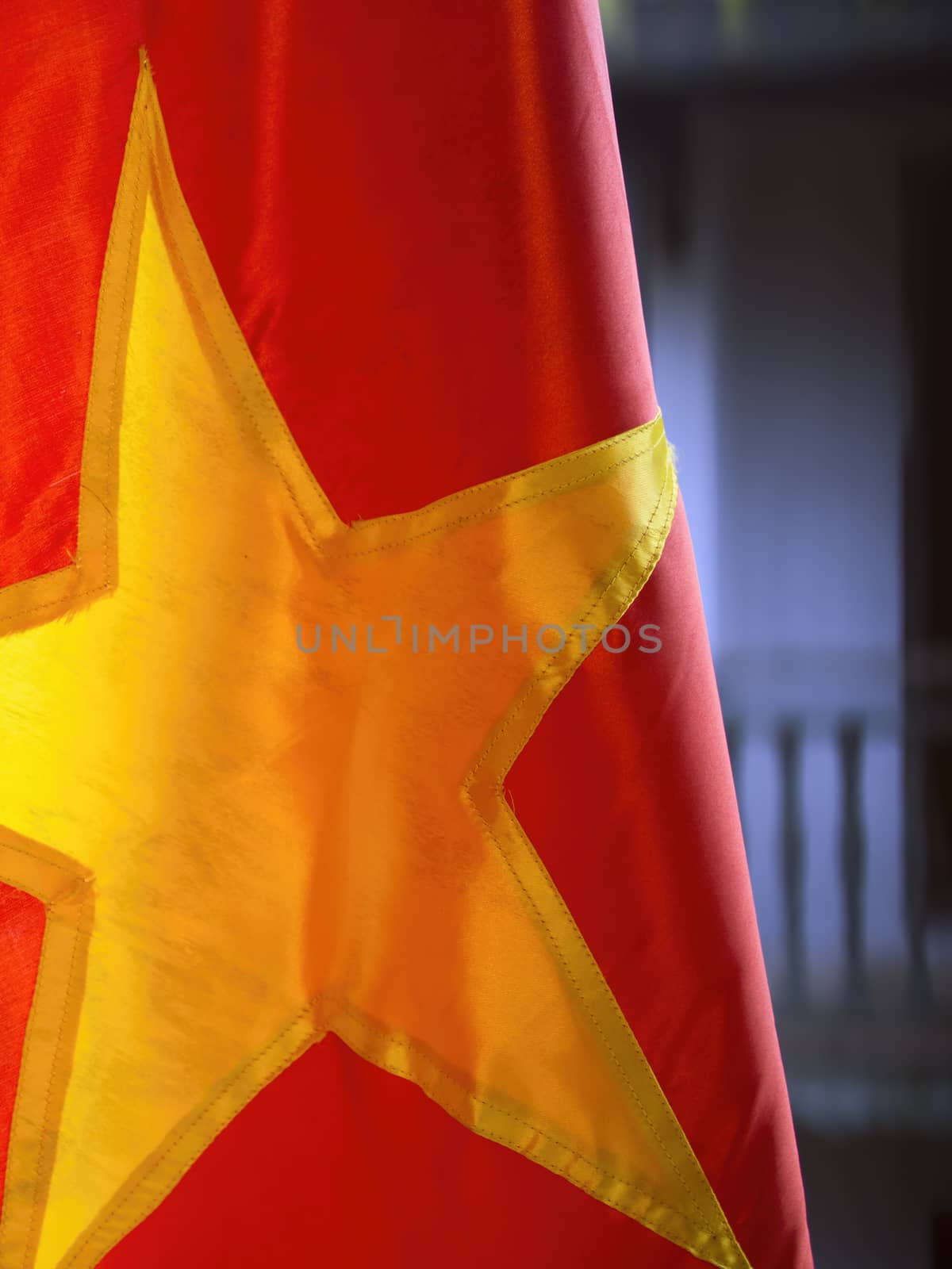 close up of red vietnamese flag with buildings background