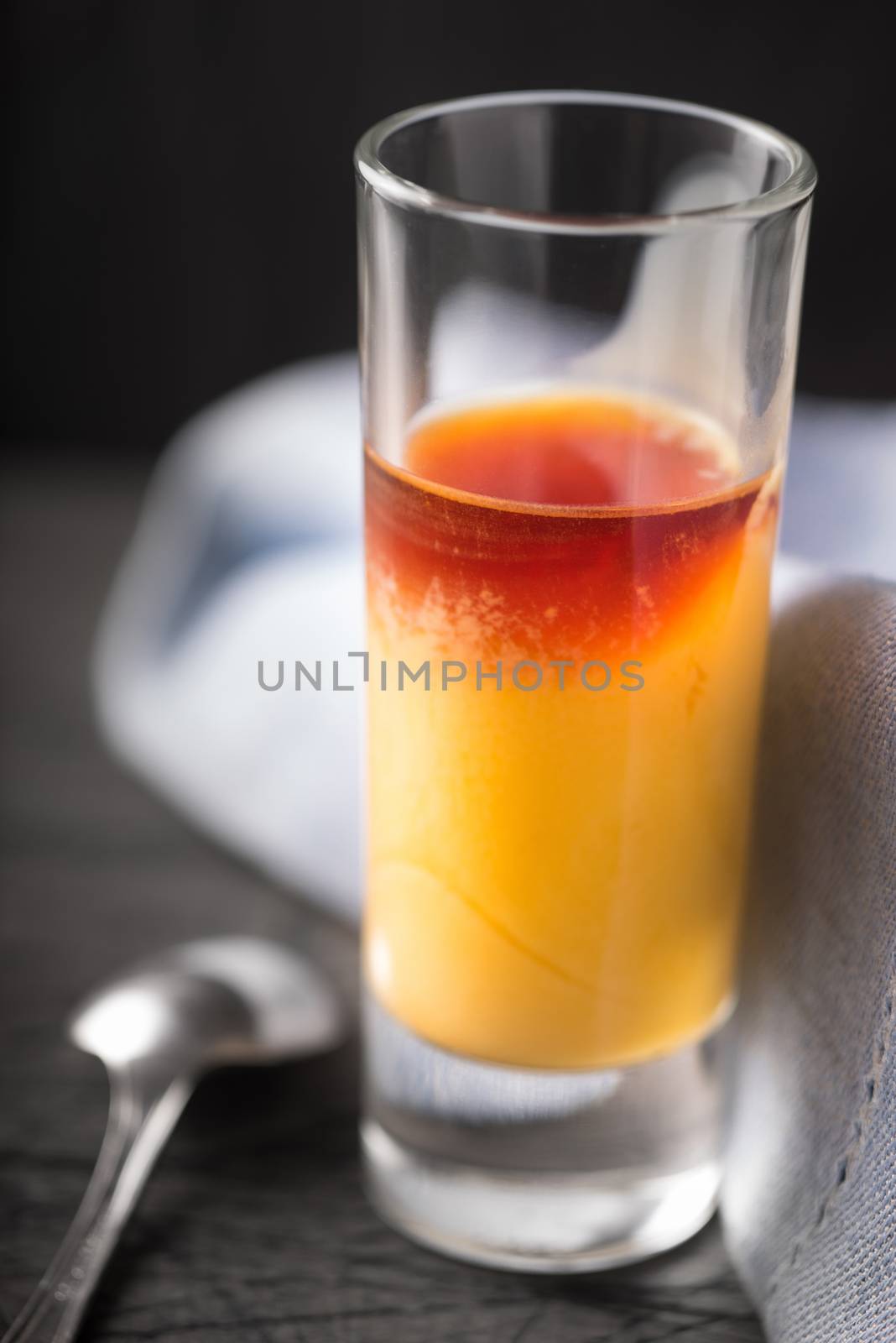 Cocktail of egg and cherry liqueur on the dark background vertical