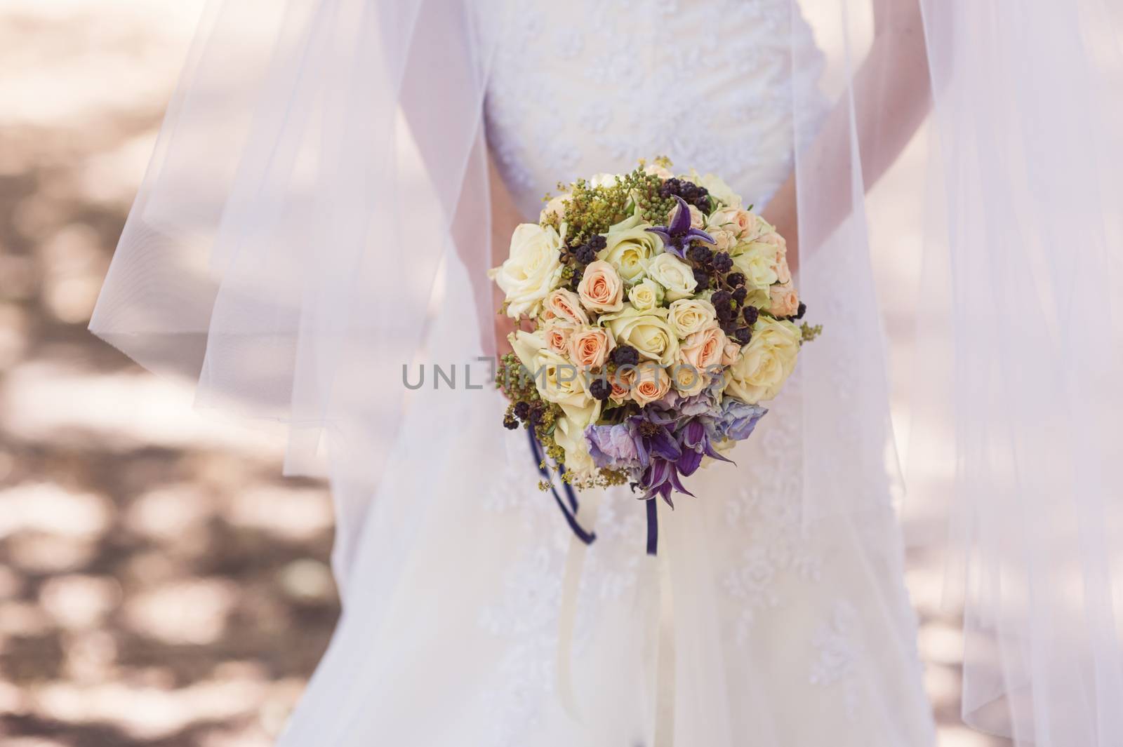 bride holding a beautiful bridal bouquet on the walk.
