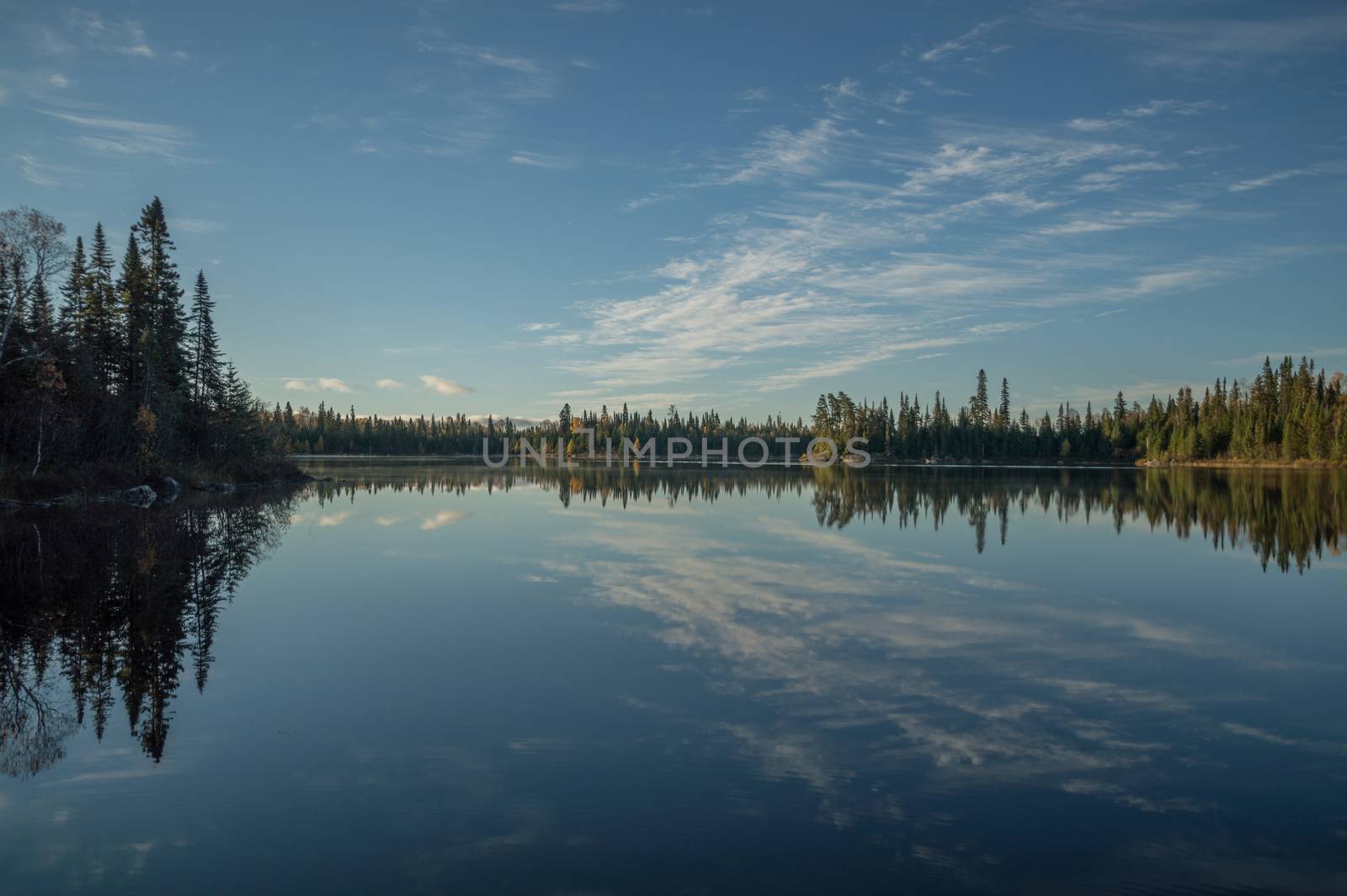 Still Northern Ontario lake in early morning with reflected clou by Sublimage