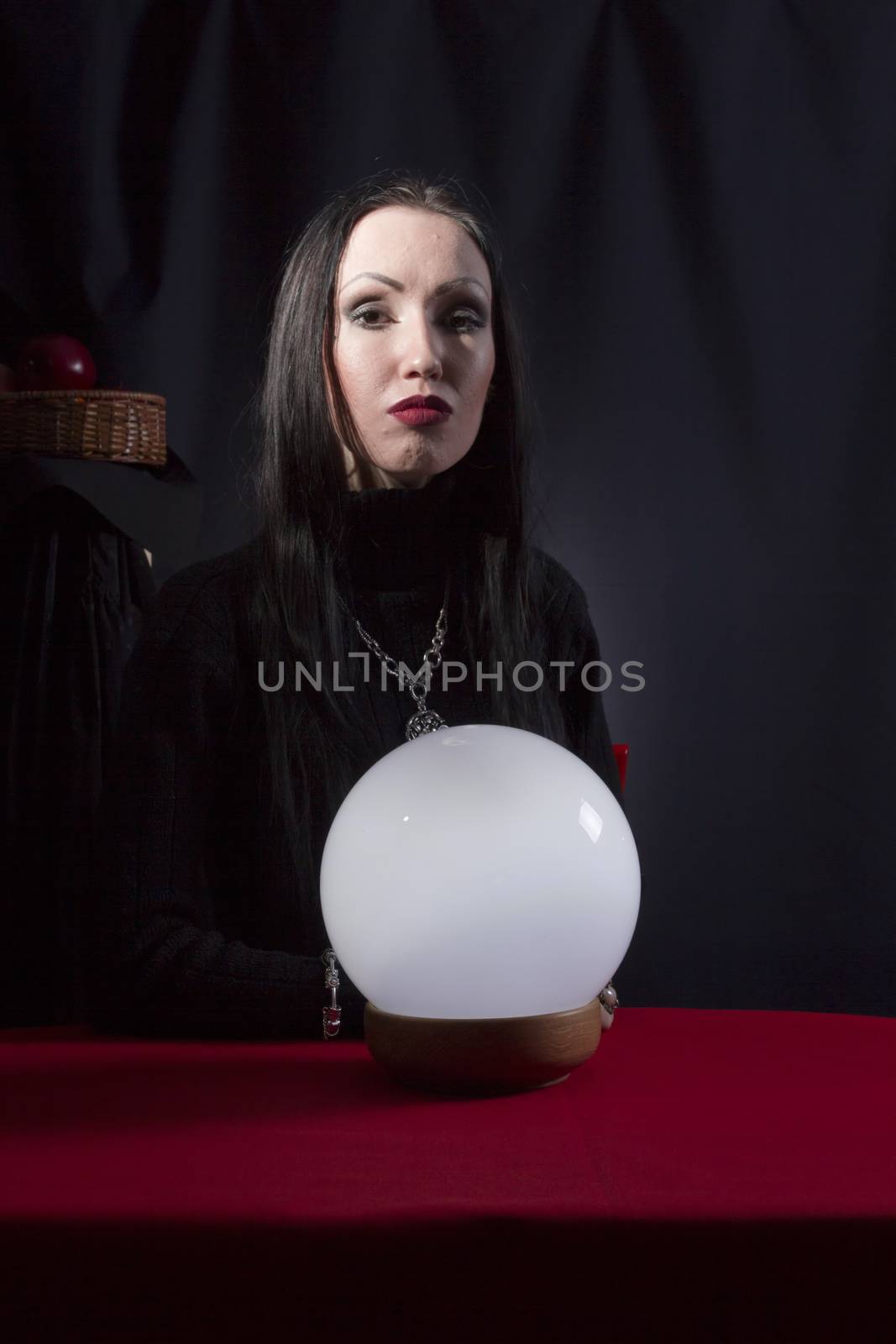 Fortune teller with a magic ball on a black background