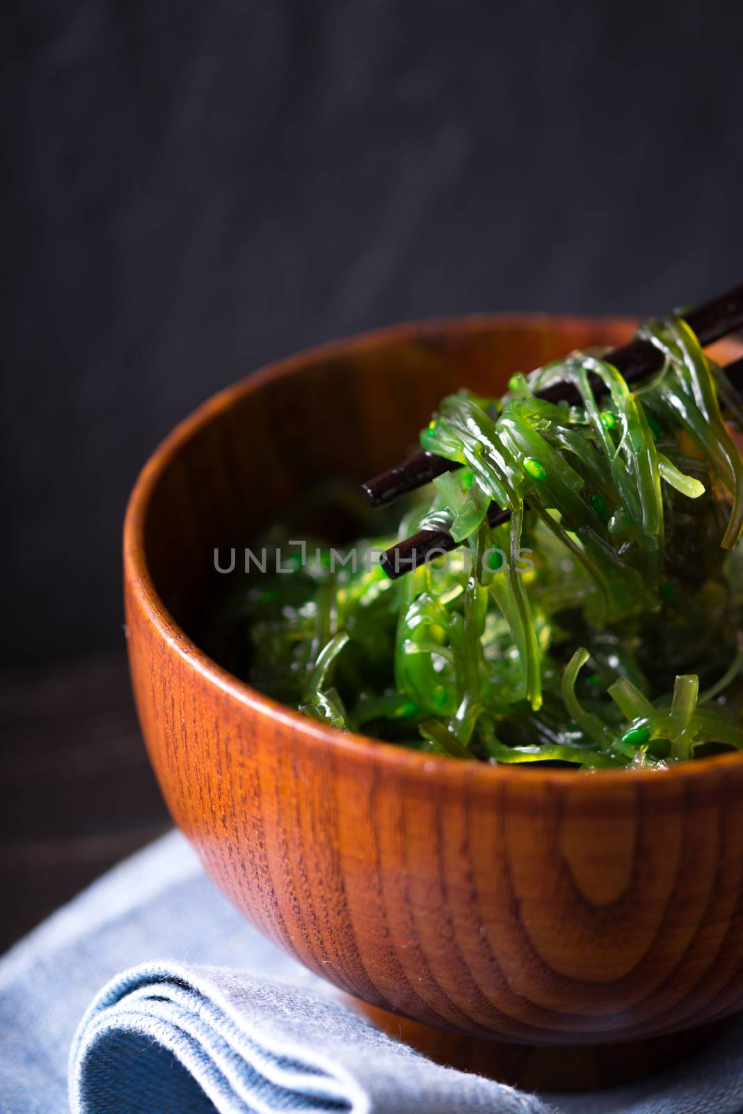 Wooden bowl with chuka salad on the dark background
