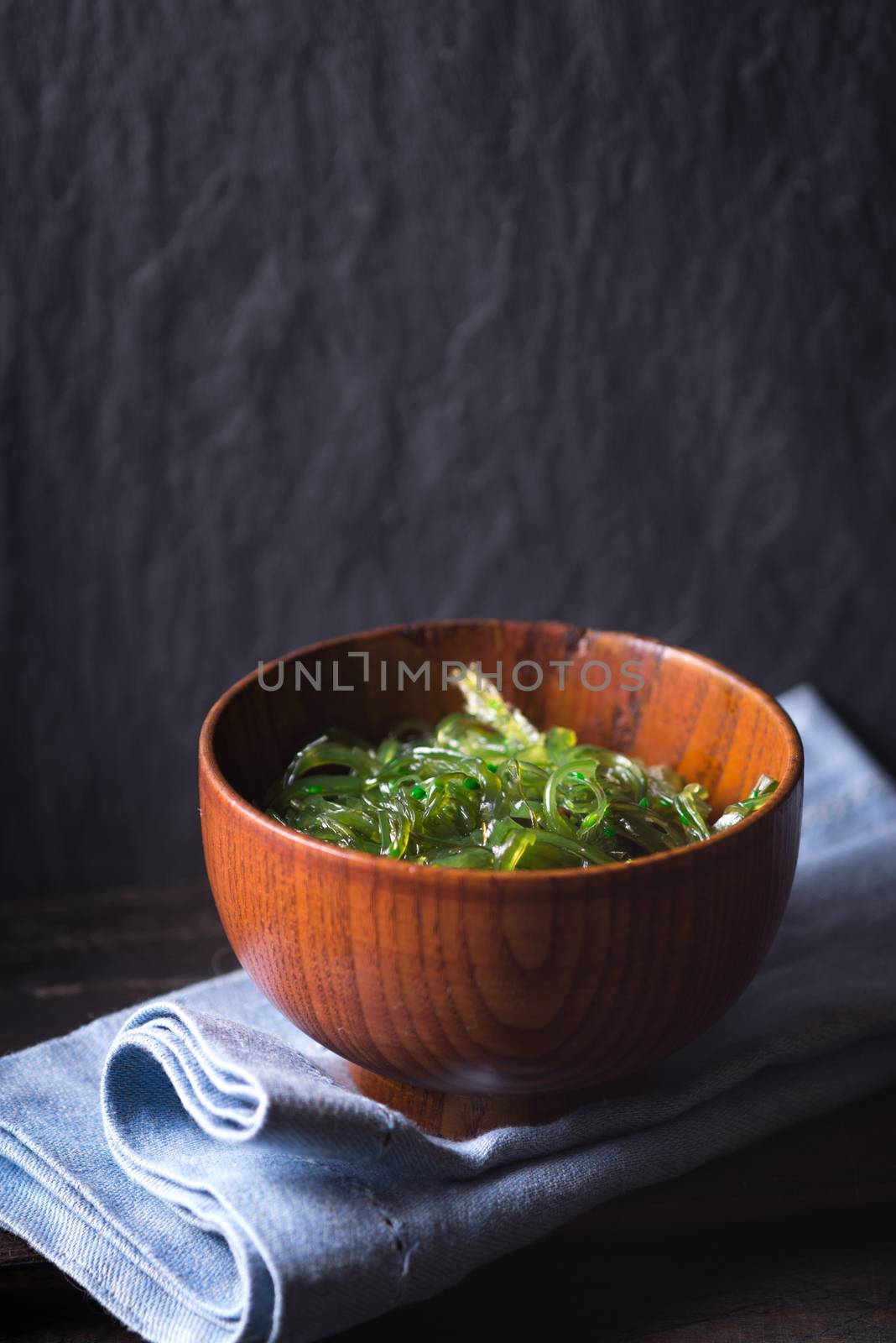 Chuka salad  in the wooden bowl  on the dark background vertical by Deniskarpenkov