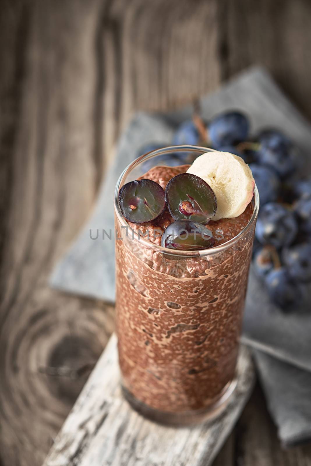 Chocolate chia pudding with fruit in the glass on the wooden table