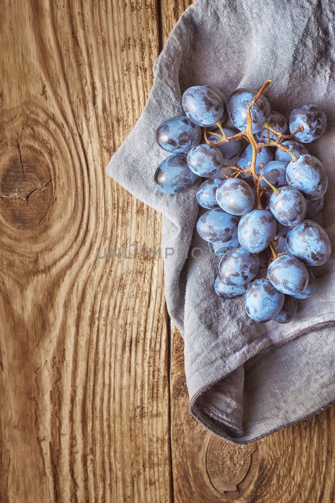Bunch of grapes on the wooden table top view by Deniskarpenkov