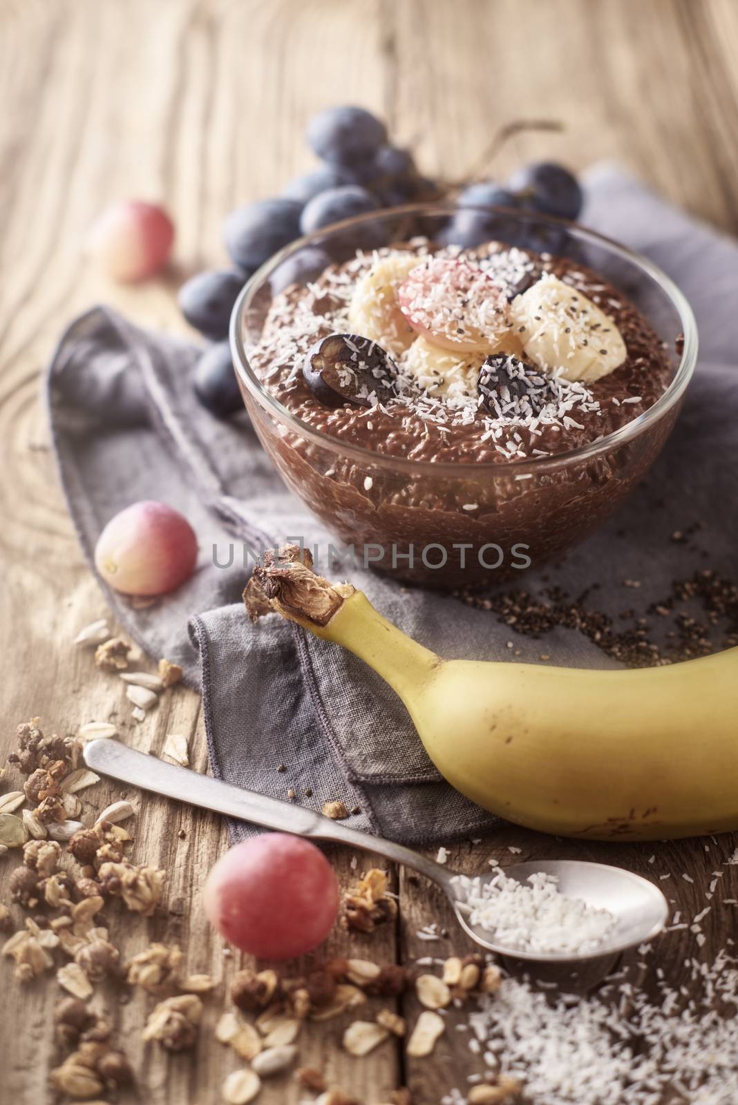 Chocolate chia pudding with fruit in the glass bowl on the wooden table