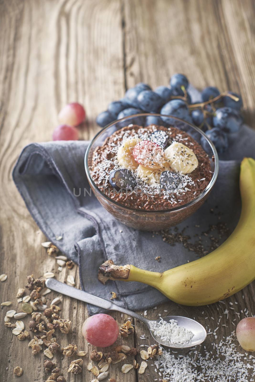 Chocolate chia pudding with fruit in the glass bowl vertical by Deniskarpenkov