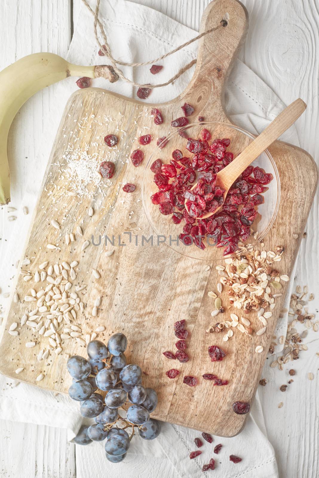 Dried cranberries  with cereal and fruits on the  white wooden table top view by Deniskarpenkov