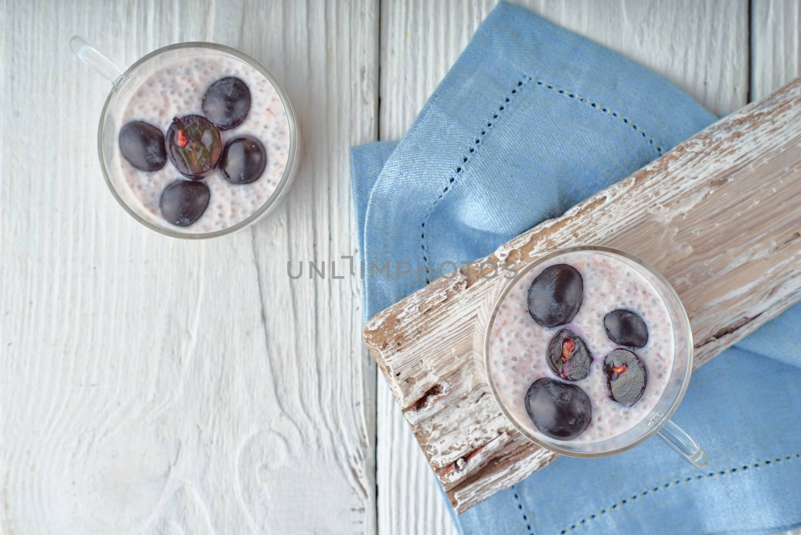Chia pudding with grapes on the white wooden table top view by Deniskarpenkov