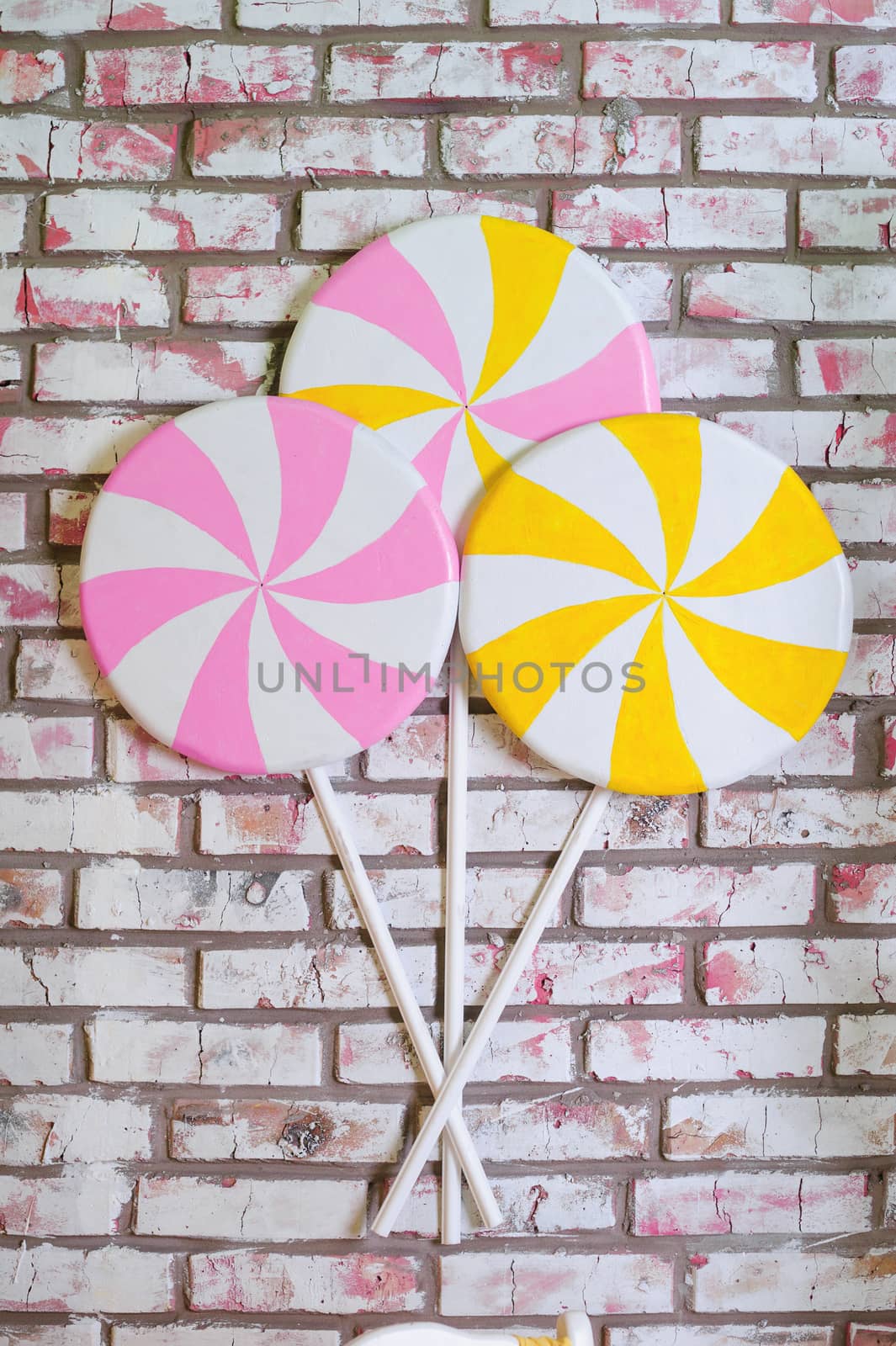 multi-colored lollypops at the brick wall background.