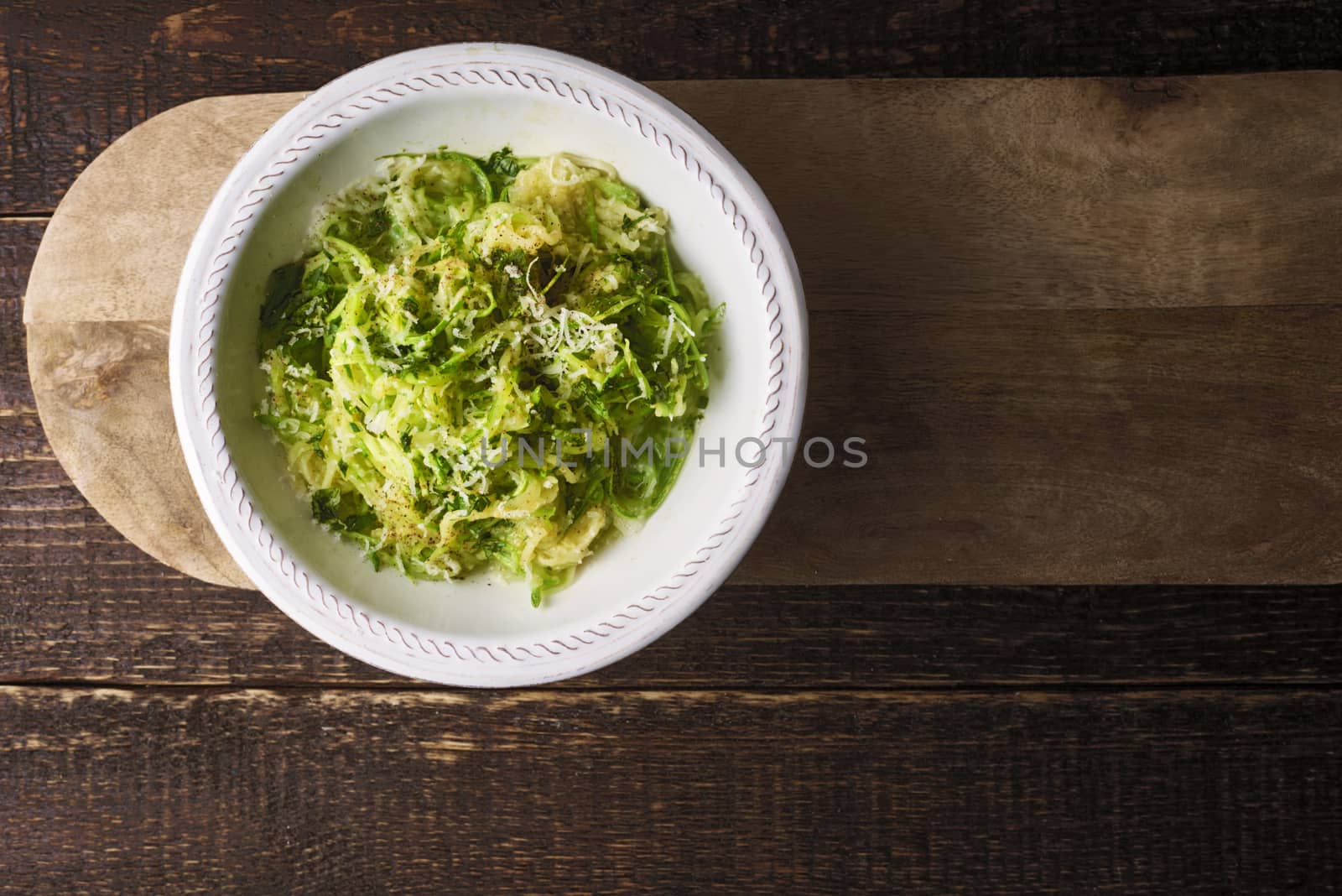 Zucchini noodles with cheese on the wooden table top view