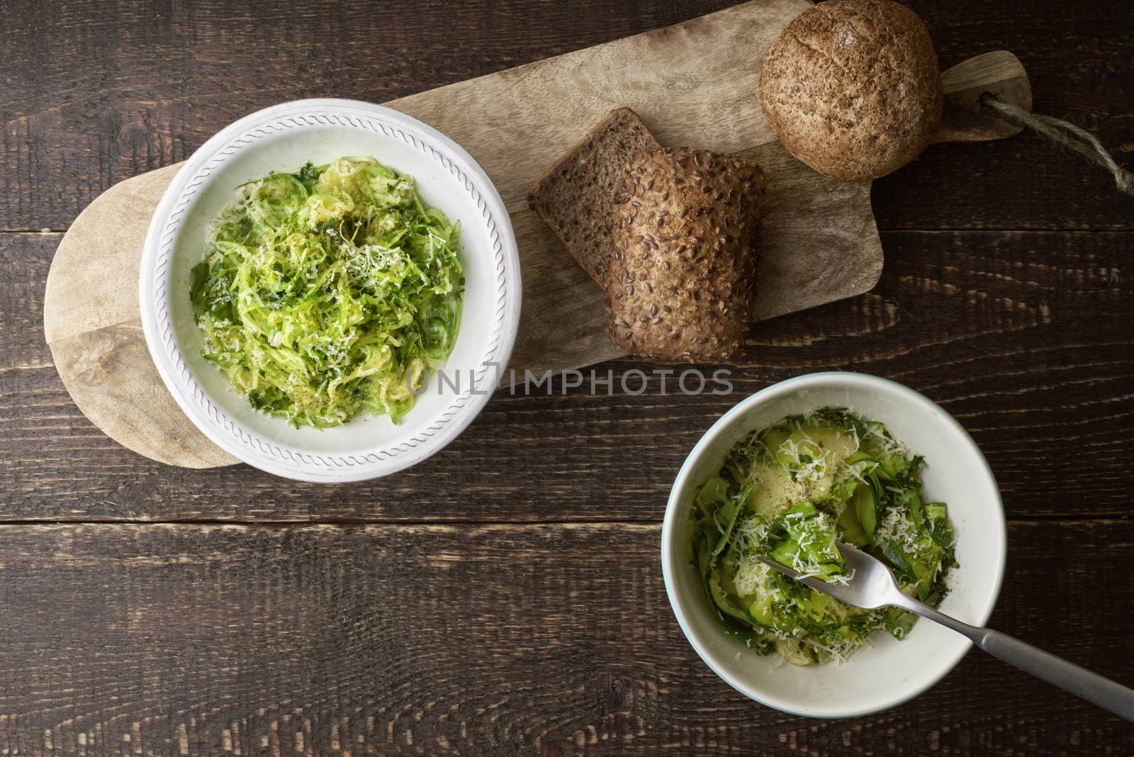Zucchini noodles with cheese and bread on the wooden table top view by Deniskarpenkov