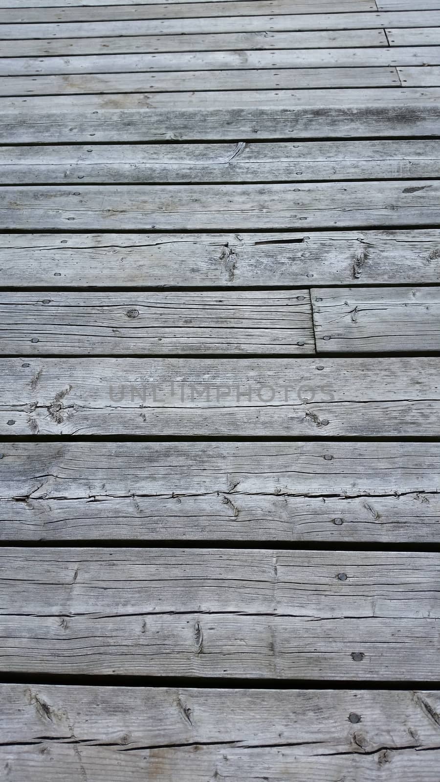 Silvery worn wood planks run horizonally as a background with character. Top planks recede into distance.