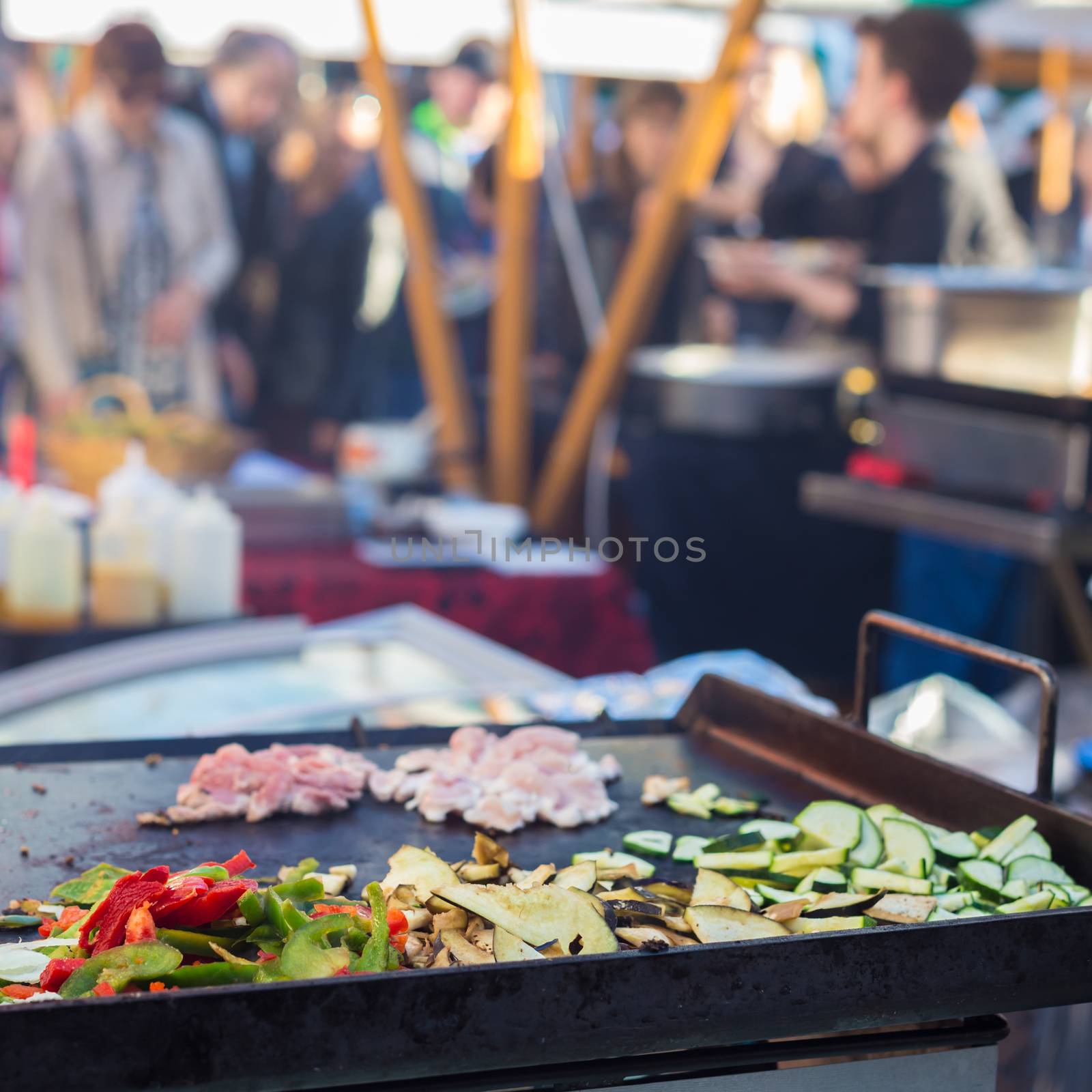 Chef making chicken with grilled vegetable tortilla wrap outdoor on street stall on Open kitchen international food festival event. Street food ready to serve on a food stall.