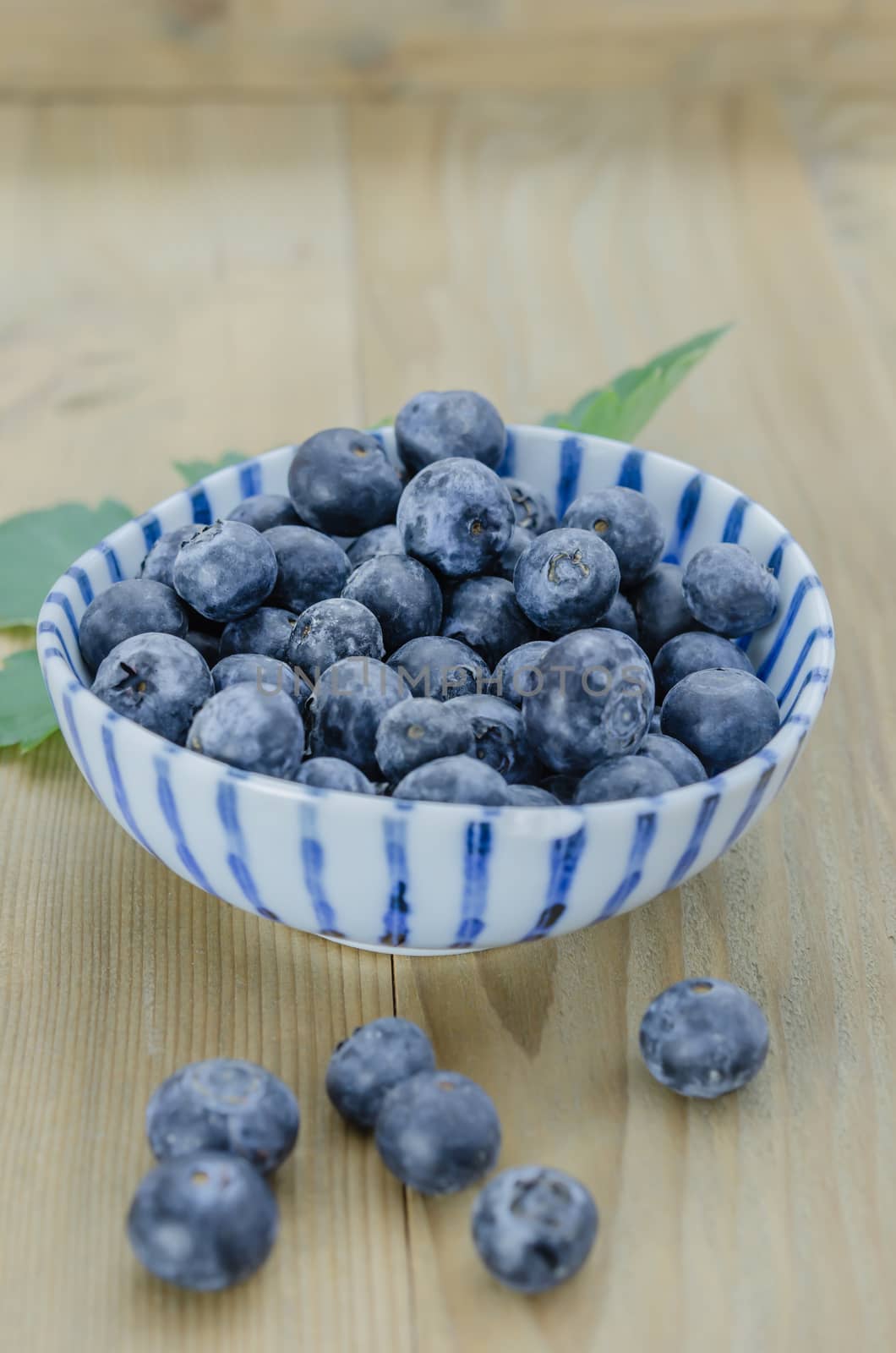 Blueberries in a bowl on a wooden background