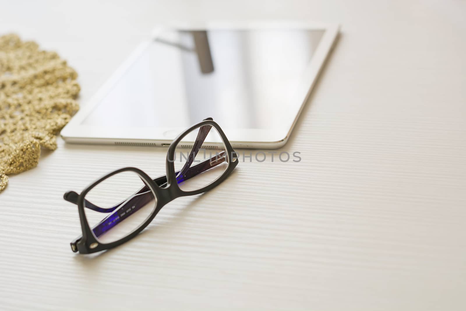 glasses and tablet on a white table