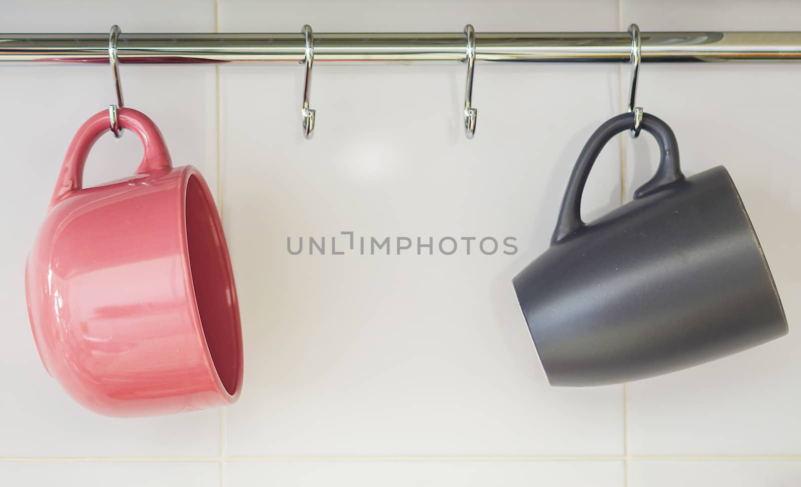 Two hanging mugs, one pink and one gray
