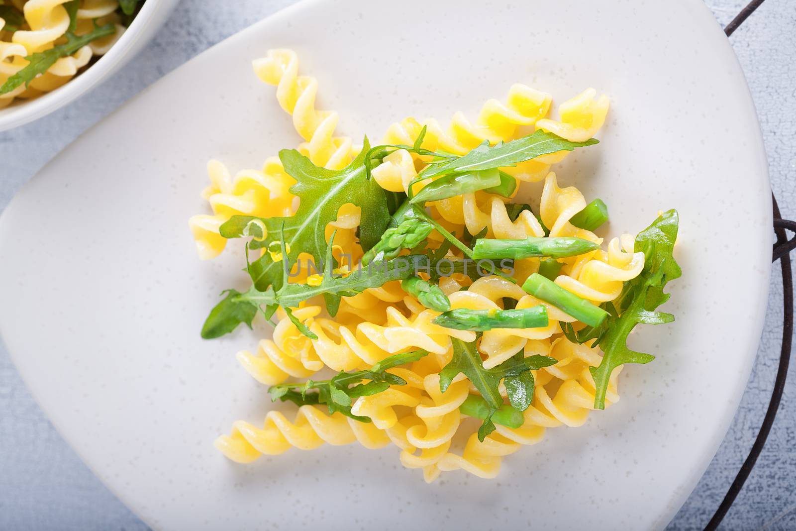 Pasta salad with asparagus and arugula on a plate