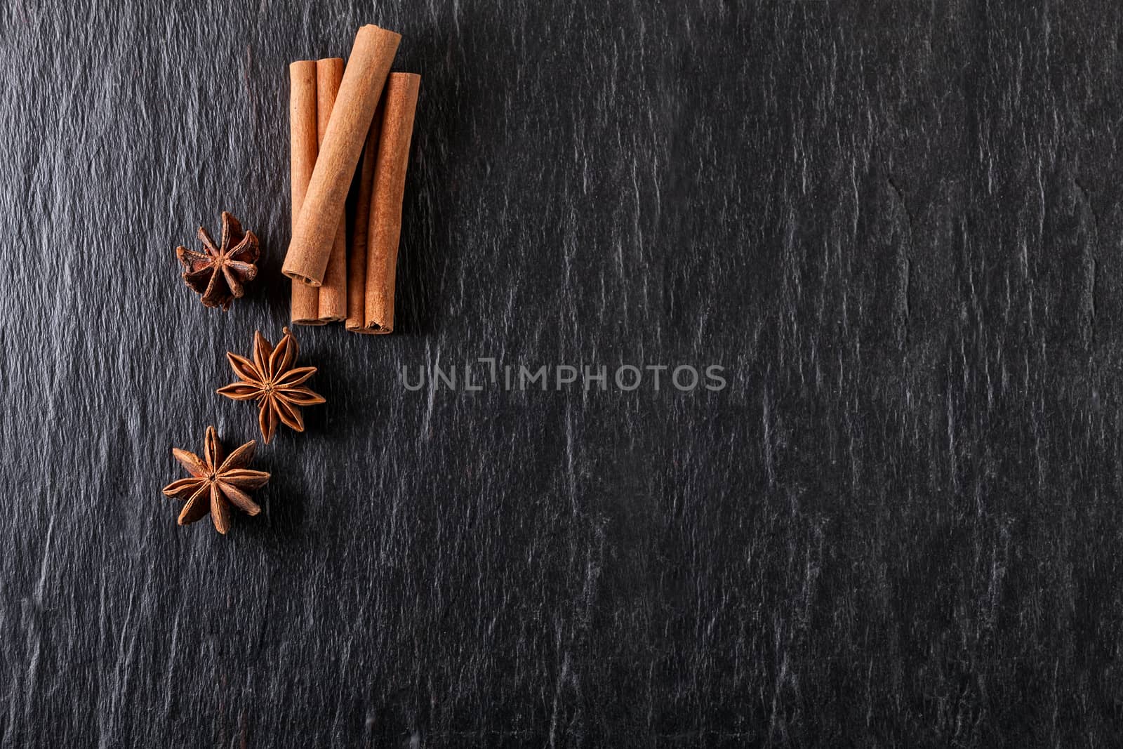 Cinnamon sticks, anise on a stone plate.