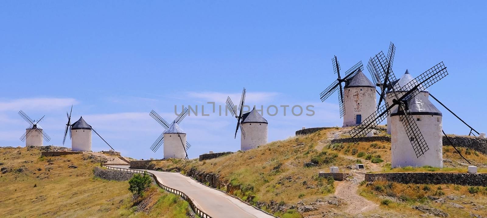 white old windmills in a row in Consuega, Spain