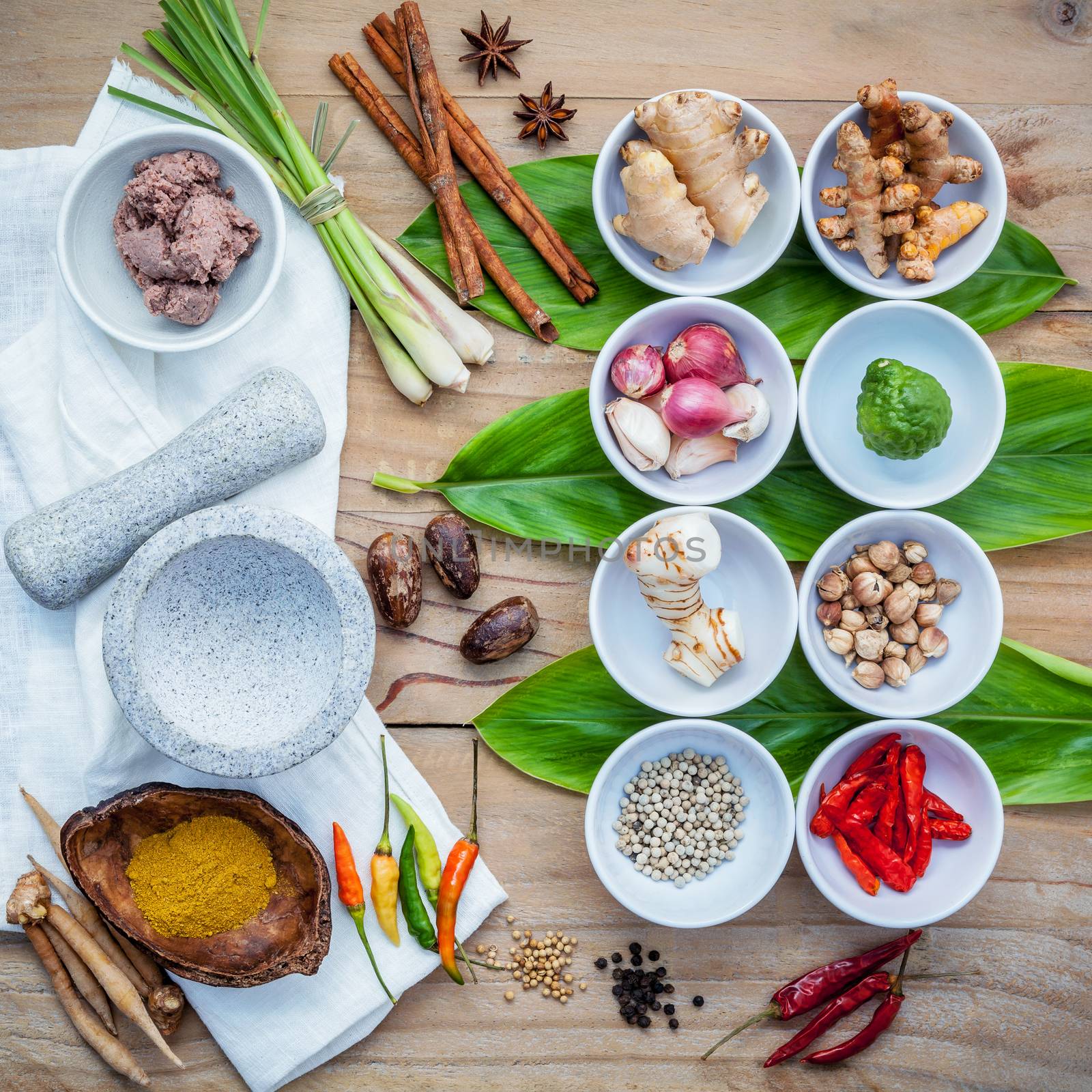 Various of thai food cooking ingredients for spice red curry paste ingredient of thai popular food on galanga leaf background. Spices ingredients chili ,pepper, nutmeg, garlic and Kaffir lime leaves.