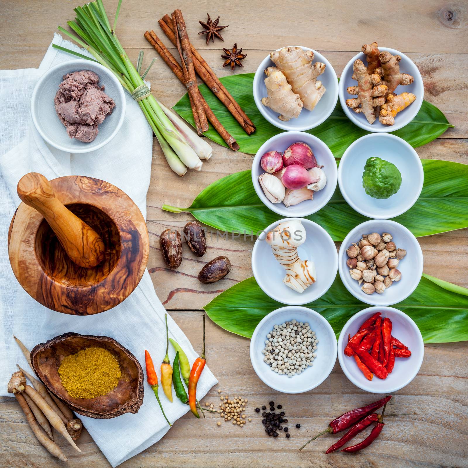 Various of thai food cooking ingredients for spice red curry paste ingredient of thai popular food on galanga leaf background. Spices ingredients chili ,pepper, nutmeg, garlic and Kaffir lime leaves.