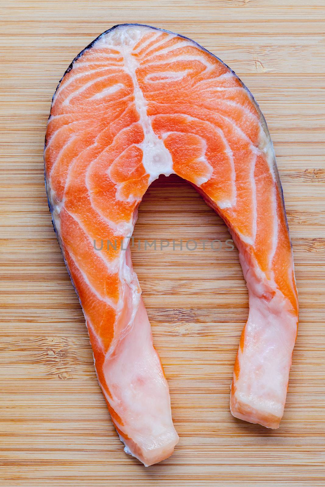 Fresh salmon fillet sliced flat lay on bamboo cutting board. Fresh salmon fillet sliced tempts buyers at fresh seafood stall.