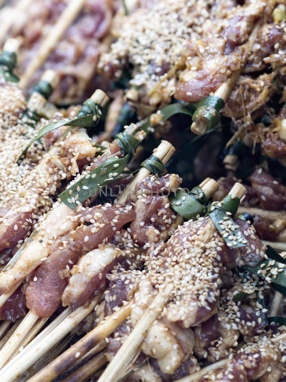 uncooked pork skewers in hoi an vietnam by zkruger