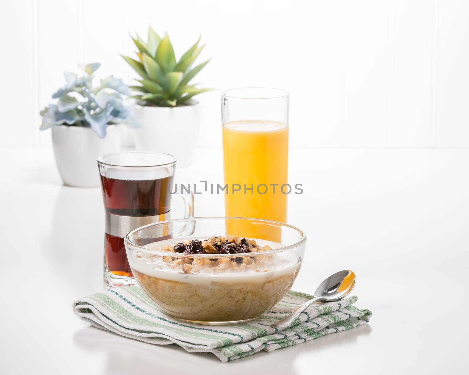 Bowl of hot oatmeal with coffee and orange juice.