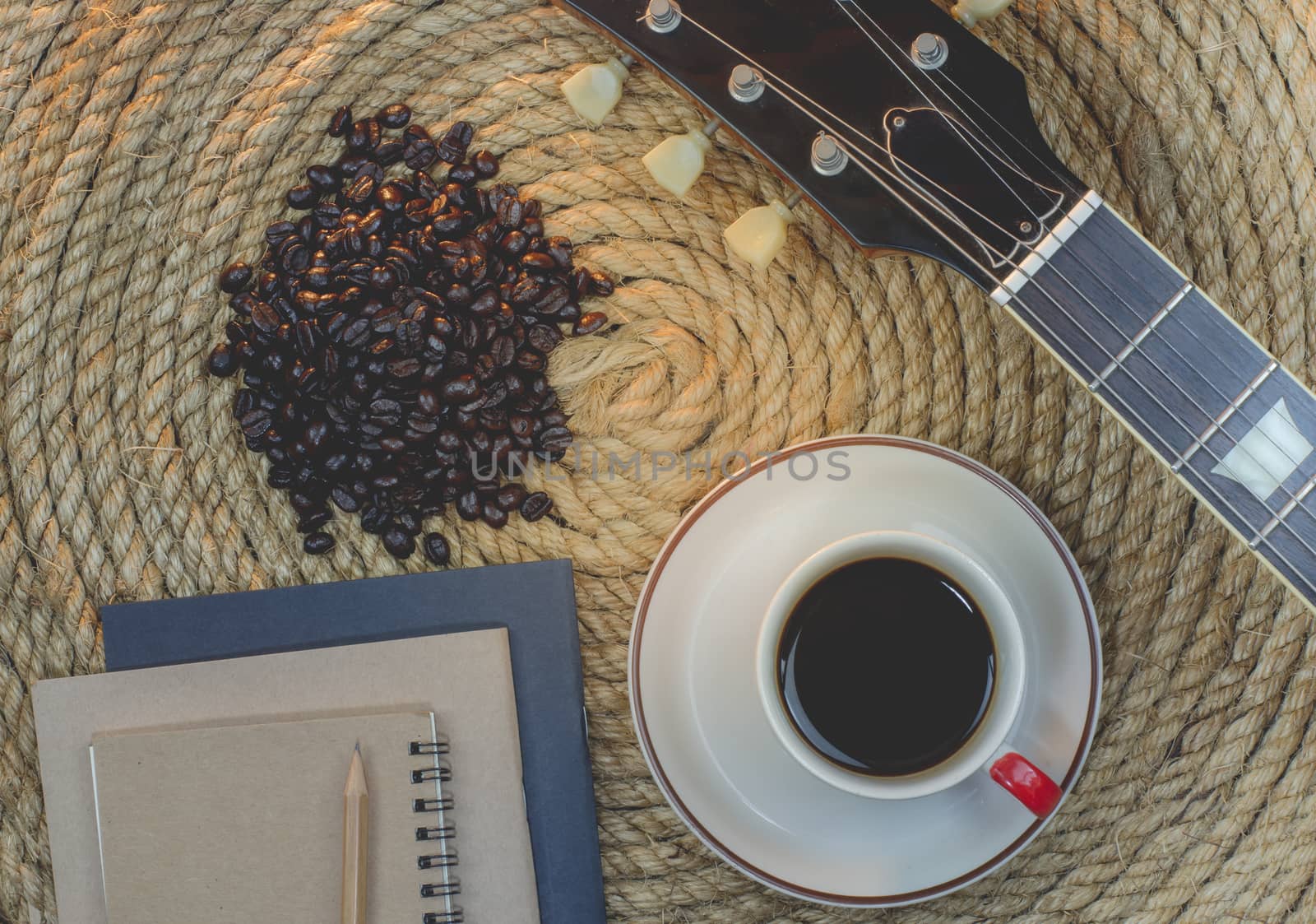 Cup of coffee with  notebook on a jute rope.