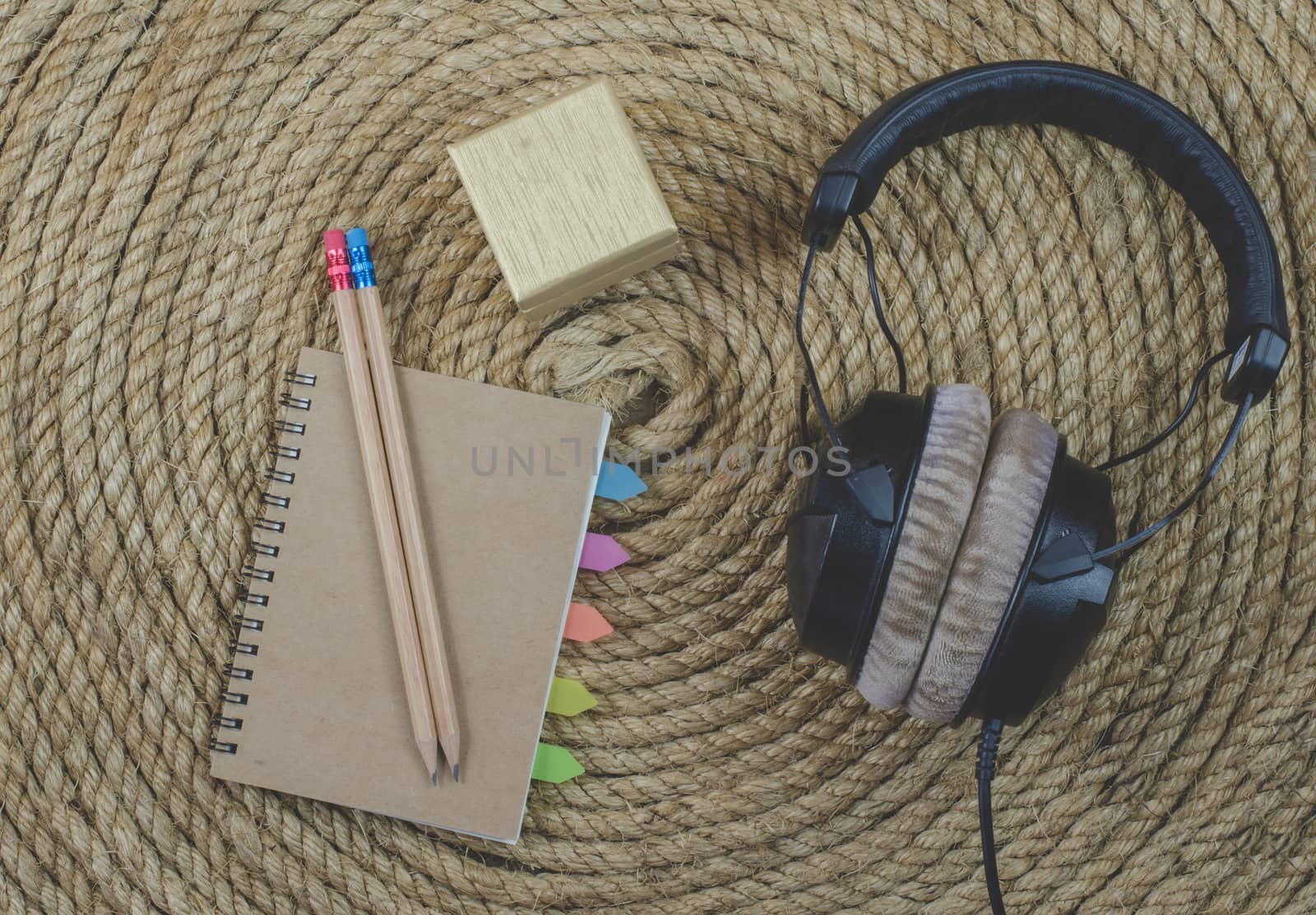 notebook and headphone music  on a jute rope background