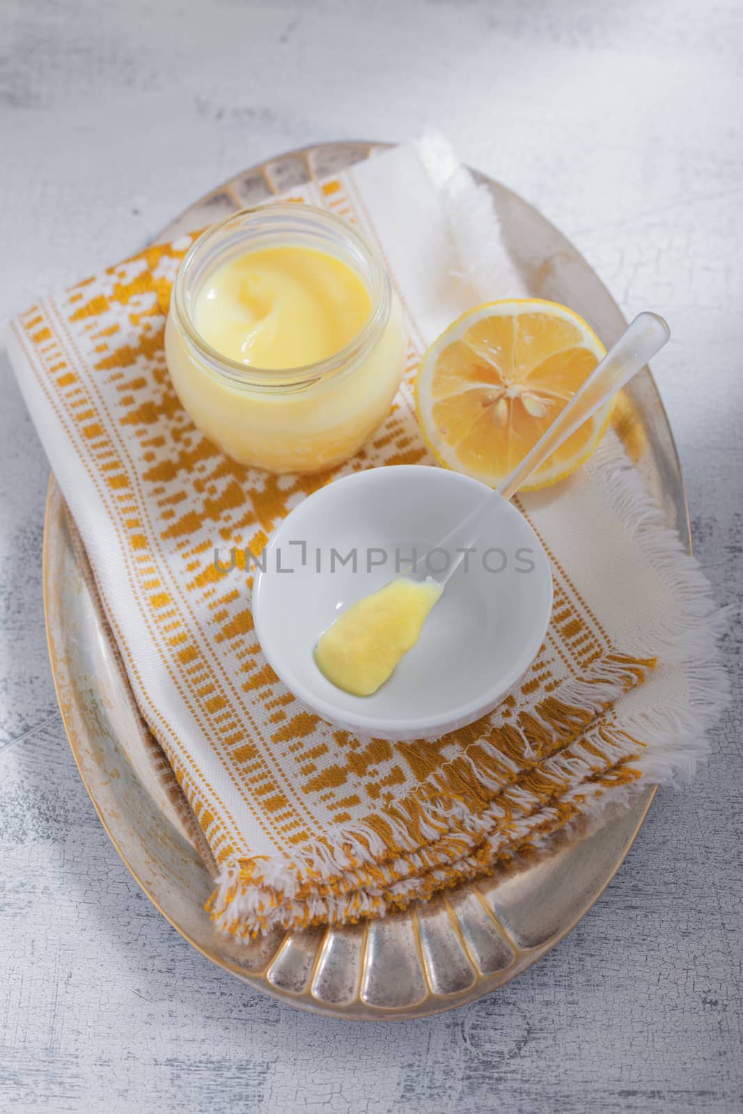Lemon kurd with a spoon served on a table.