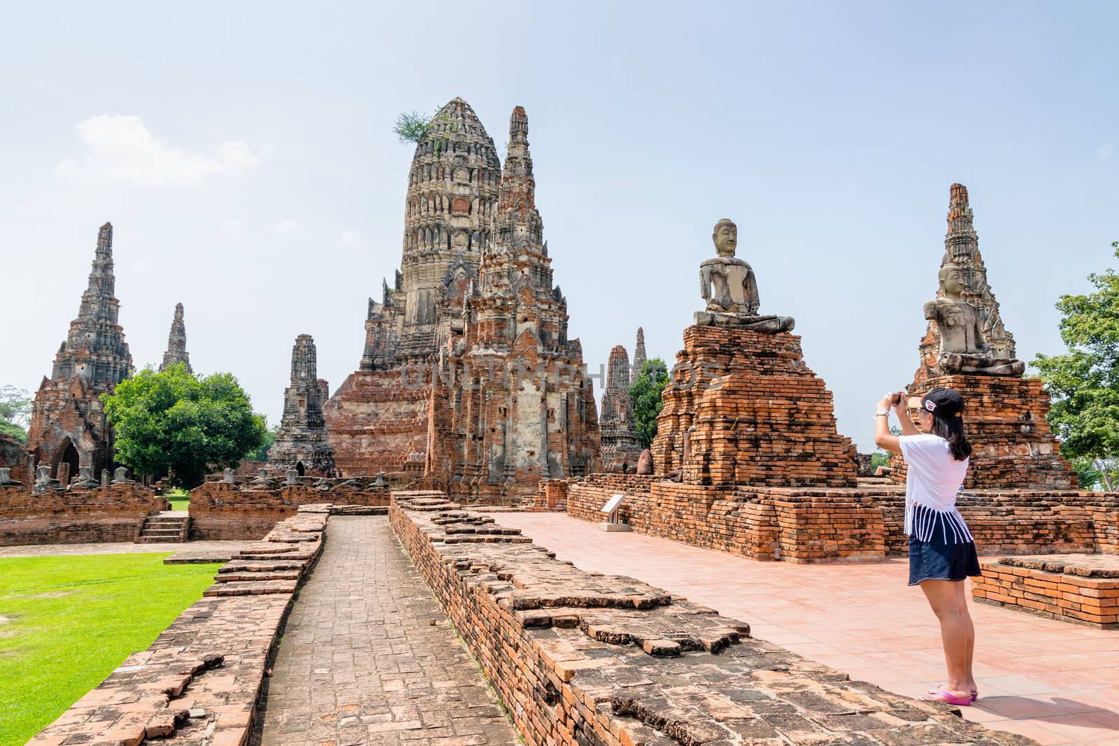 Tourist teenage girl take a photo ancient pagoda of Wat Chaiwatthanaram is buddhist temple famous tourist attraction religion at Ayutthaya Historical Park, Phra Nakhon Si Ayutthaya, Thailand
