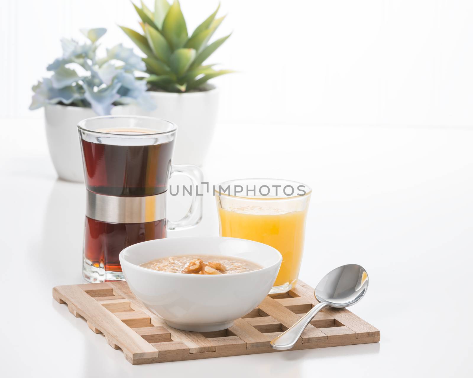 Bowl of maple walnut flavored oatmeal with coffee and juice.