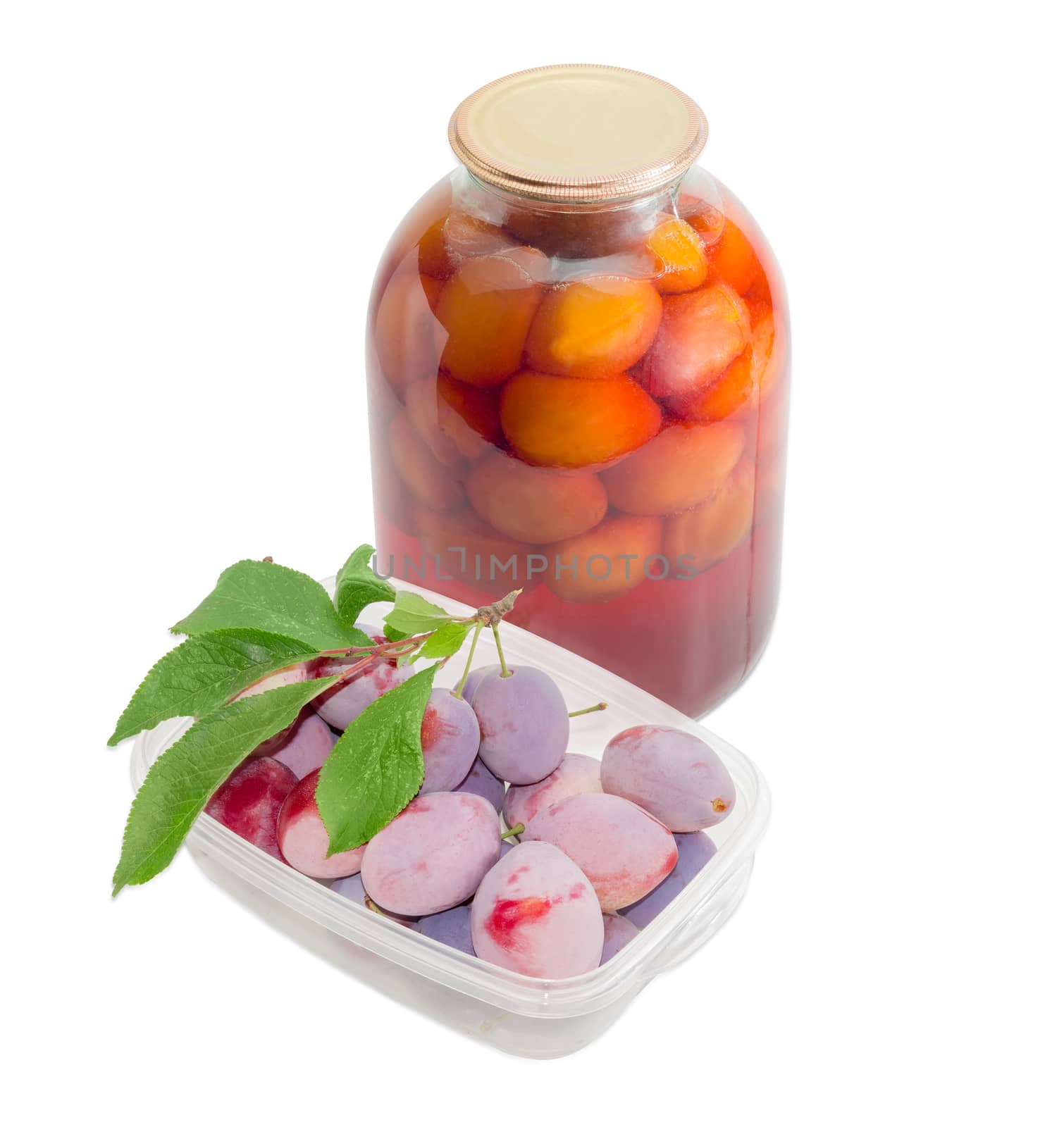 Fresh ripe plums with a few leaves in transparent plastic tray and canned plums in glass jar on a light background
