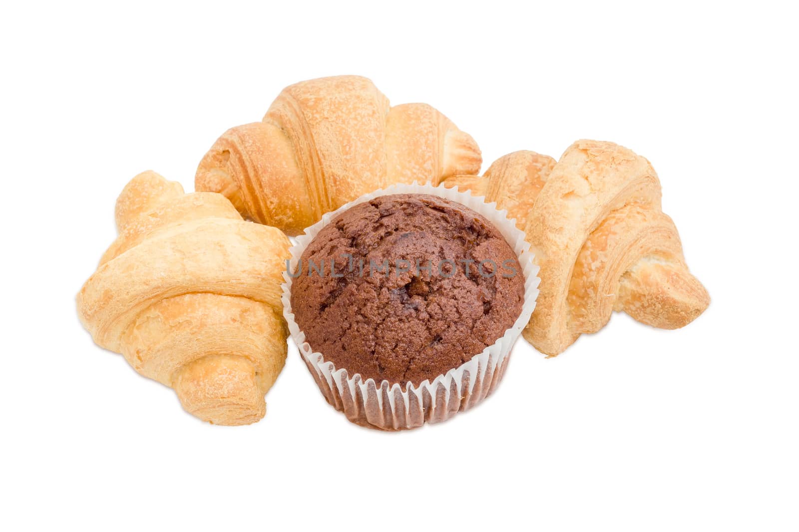 Three small croissant and sweet chocolate muffin in a paper cup on a light background
