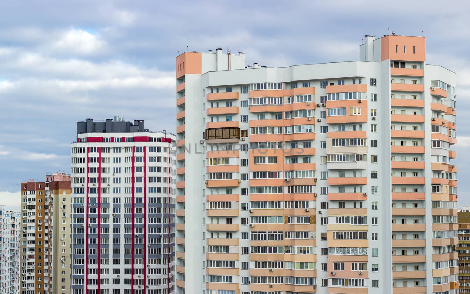 Fragment of a housing estate with typical modern multi-storey apartment buildings in a big city cloudy day
