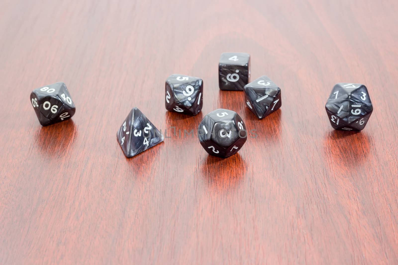 Set of specialized polyhedral dice with numbers used in role-playing games on a wooden surface
