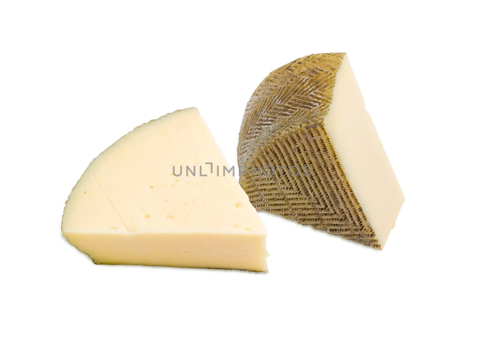 Two pieces of semi-hard Spanish cheese with dark coating manufactured from mixtures of cow and sheep milk on a light background
