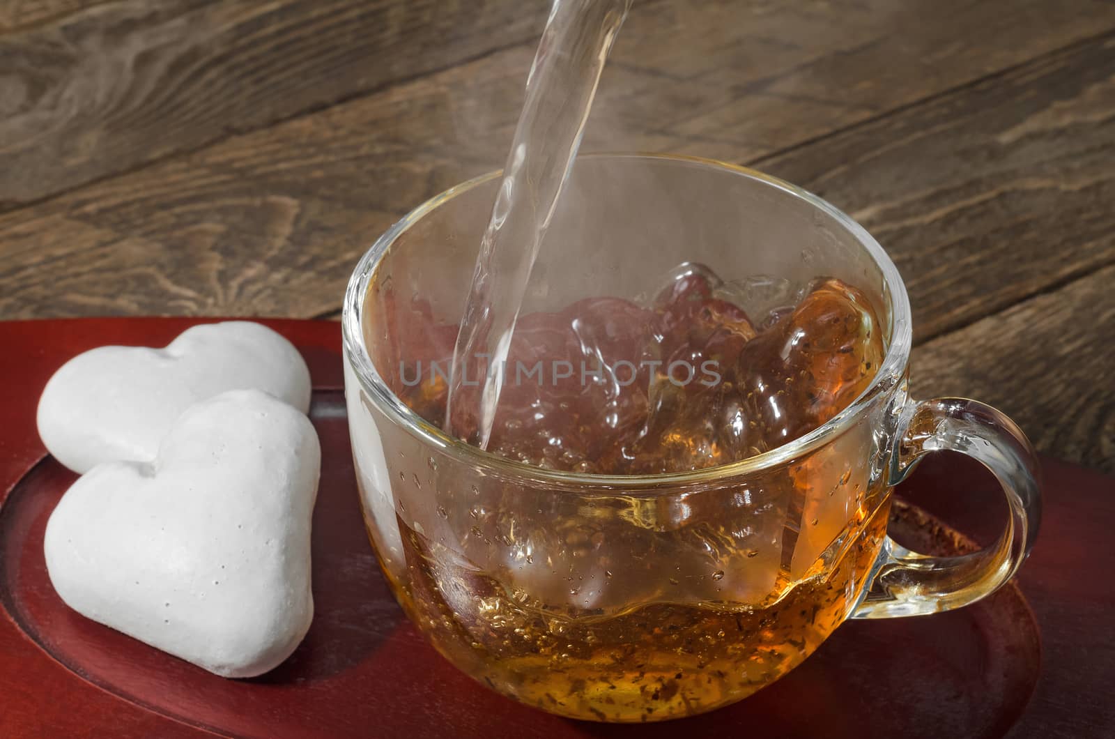 Gingerbread cookies in the shape of a heart and hot tea poured, steam rises