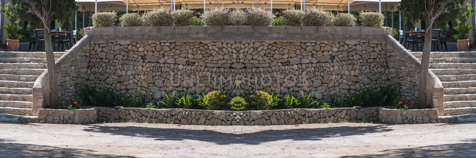 Mediterranean retaining wall of traditional natural stone for a terrace of a restaurant.