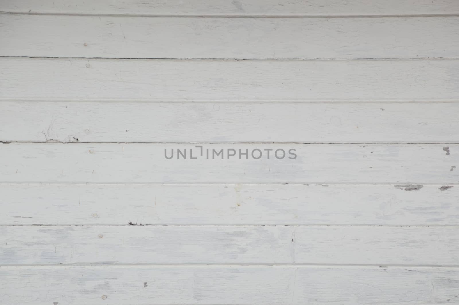 Old horizontal white painted boards on a boathouse. Weathered and a little grungy