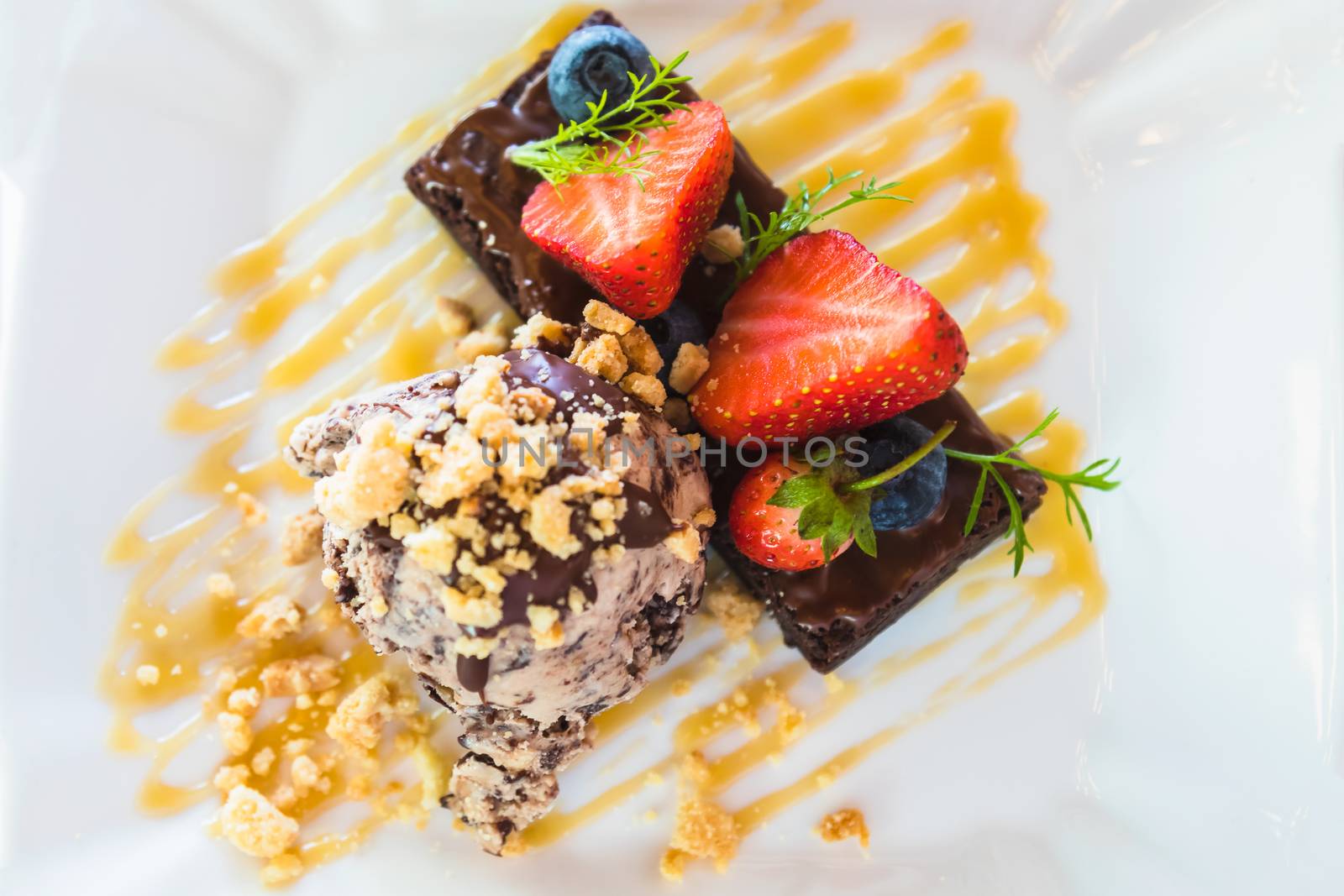 top view of ice cream and chocolate cake with strawberry