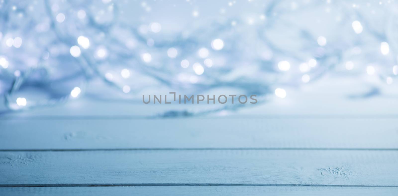 Glowing garland defocused bokeh lights on wooden background